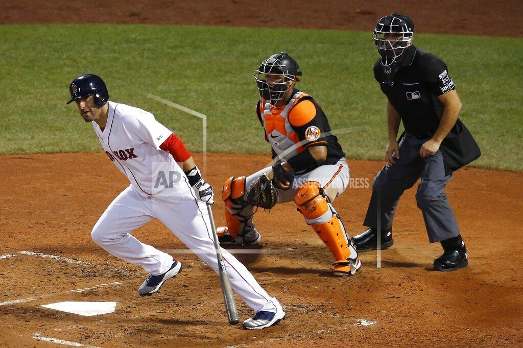 Michael Dwyer Boston Red Sox's J.D. Martinez, left, follows through on an RBI-double in front of Baltimore Orioles' Pedro Severino during the third inning of an opening day baseball game at Fenway Park, Friday, July 24, 2020, in Boston. (AP Photo/Michael Dwyer)