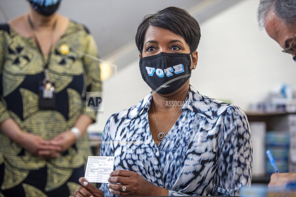 Alyssa Pointer Atlanta Mayor Keisha Lance Bottoms shows off her vaccination card after receiving a Pfizer BioNTech shot by Dr. Carlos del Rio, Emory School of Medicine & Grady Health System Dean Executive Associate Dean, at Mercedes-Benz Stadium Community Vaccination Center in Atlanta, Tuesday, March 30, 2021. (Alyssa Pointer/Atlanta Journal-Constitution via AP)
