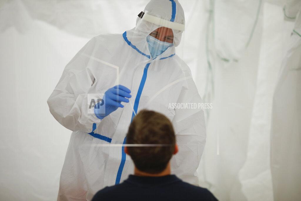 Medical staff of the German Red Cross, DRK, wears protective suit as he takes a coronavirus test at a newly set up test station at the main train station in Berlin, Germany, Monday, Aug. 17, 2020. Travellers arriving from countries considered 'at-risk' can be tested for the coronavirus free of charge at the station.(Photo/Markus Schreiber)