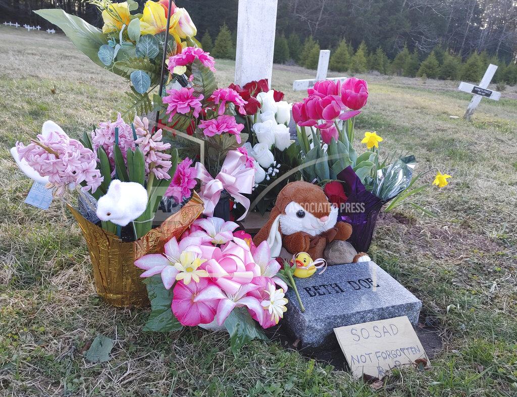 Kelly Monitz Phil Jeffries, retired funeral director and deputy coroner for Carbon County, Pa., placed a marker behind the flowers on the right, on Beth Doe and her baby’s grave with their true identities, Evelyn and Emily Grace Colon, after more than four decades, in Laurytown Road Cemetery in Lehigh Township, Pa., Sunday, April 4, 2021. Flowers and a child's toy also adorn the grave. Colon, who was known for decades here in Northeast Pennsylvania as Beth Doe, was brutally murdered and dumped off an Interstate 80 bridge in East Side borough in December 1976. (Kelly Monitz/Standard-Speaker via AP)