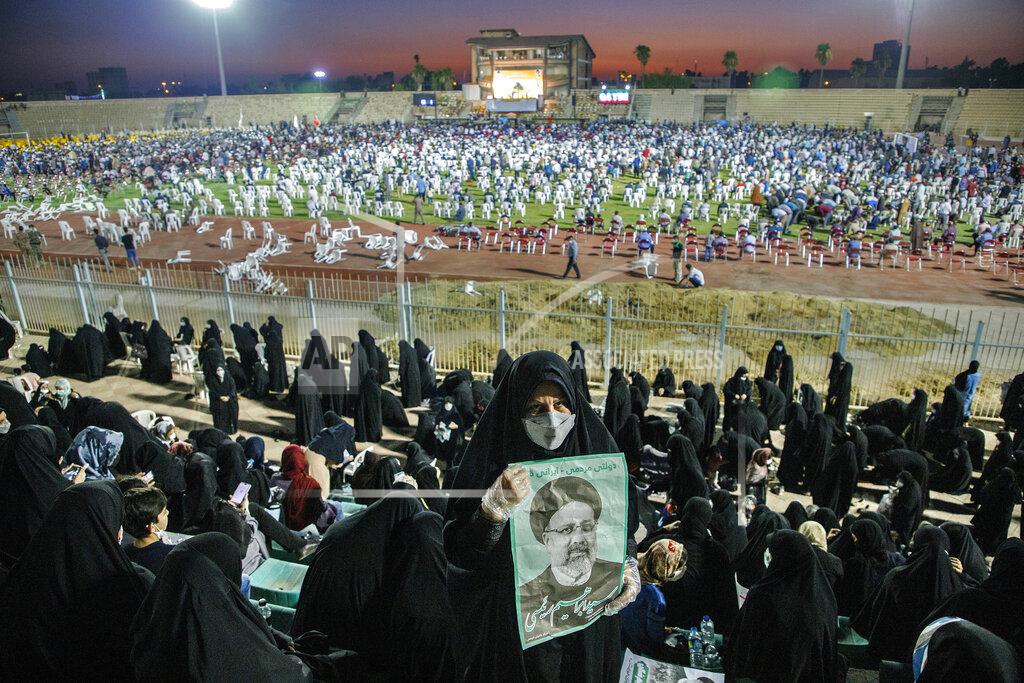 Amin Nazari In this Wednesday, June 9, 2021, photo, a supporter of the presidential candidate Ebrahim Raisi, currently judiciary chief, hold posters of him during a campaign rally at the Takhti Stadium in Ahvaz, Iran. Around 5,000 of people have gathered in a football stadium in southeastern city of Ahvaz to support the Iranian hard-line presidential candidate, Iranian media reported. (Amin Nazari/ISNA via AP)