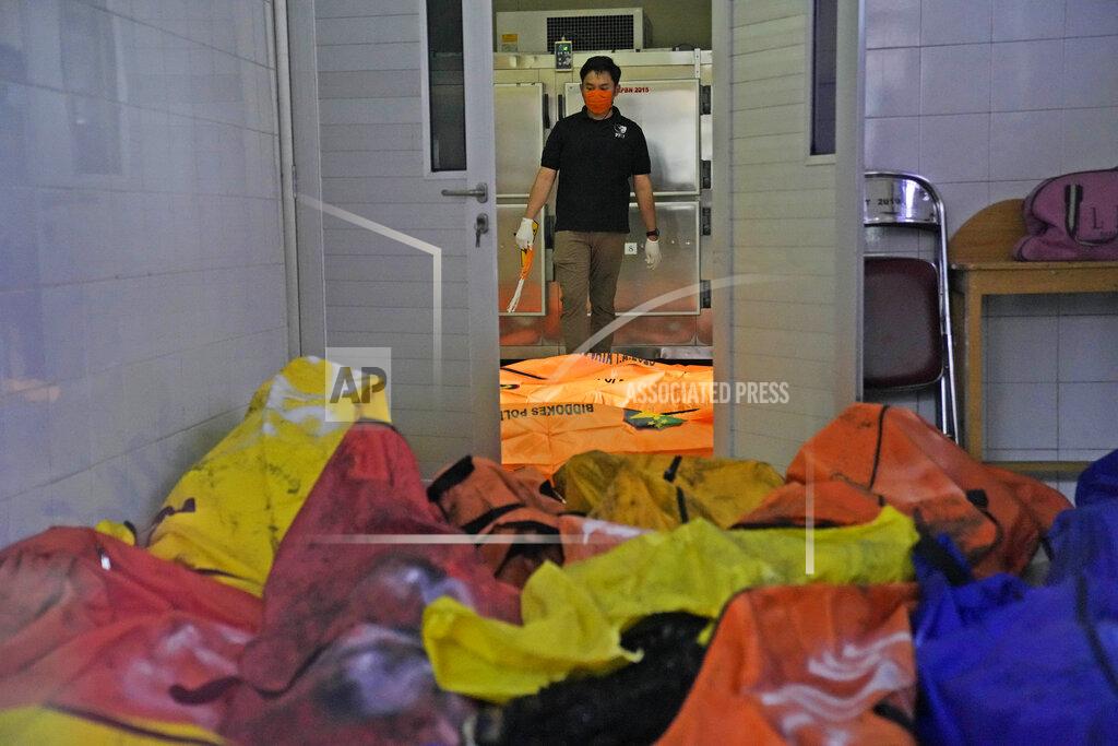 Dita Alangkara A member of police forensic team stands near body bags containing the bodies of the victims of a prison fire at the local hospital's morgue in Tangerang on the outskirts of Jakarta, Indonesia, Wednesday, Sept. 8, 2021. A massive fire raged through an overcrowded prison near Indonesia's capital early Wednesday, killing a number of inmates. (AP Photo/Dita Alangkara)