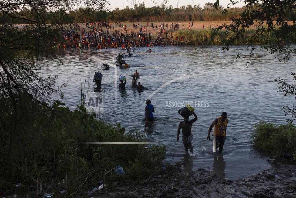 Felix Marquez Migrants wade across the Rio Grande from Del Rio, Texas, to Ciudad Acuña, Mexico, Sunday, Sept. 19, 2021. (AP Photo/Felix Marquez)