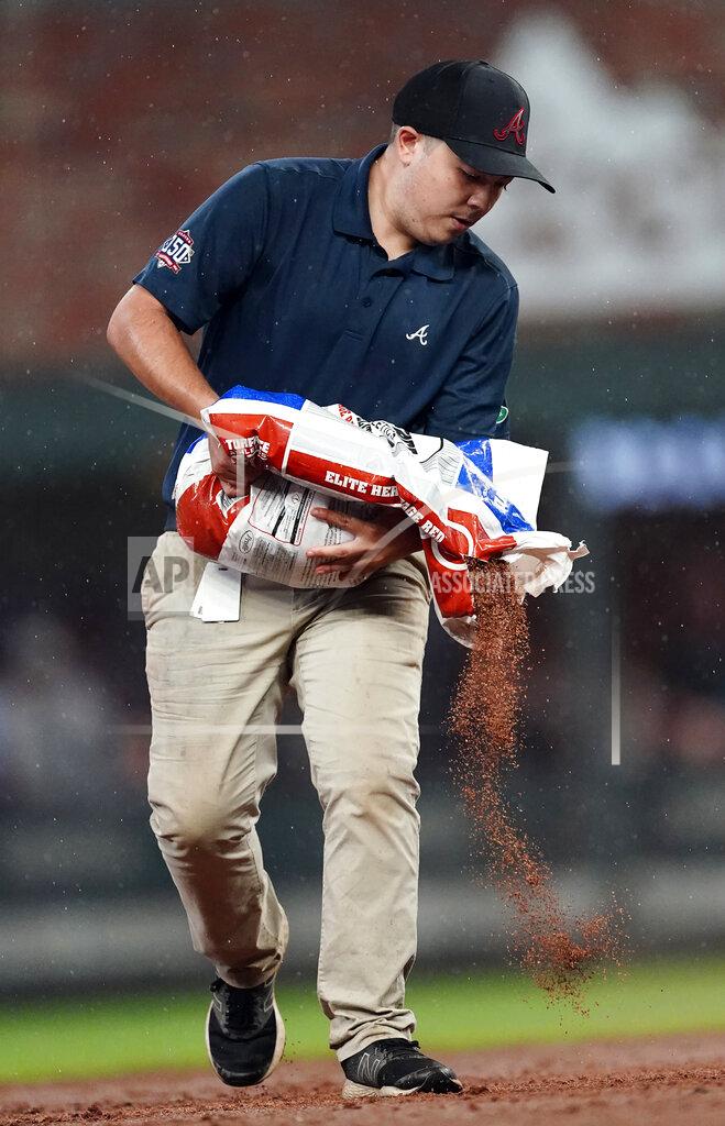 John Bazemore A member of the Atlanta Braves grounds crew works to dry the infield during the team's baseball game against the Colorado Rockies on Wednesday, Sept. 15, 2021, in Atlanta. (AP Photo/John Bazemore)