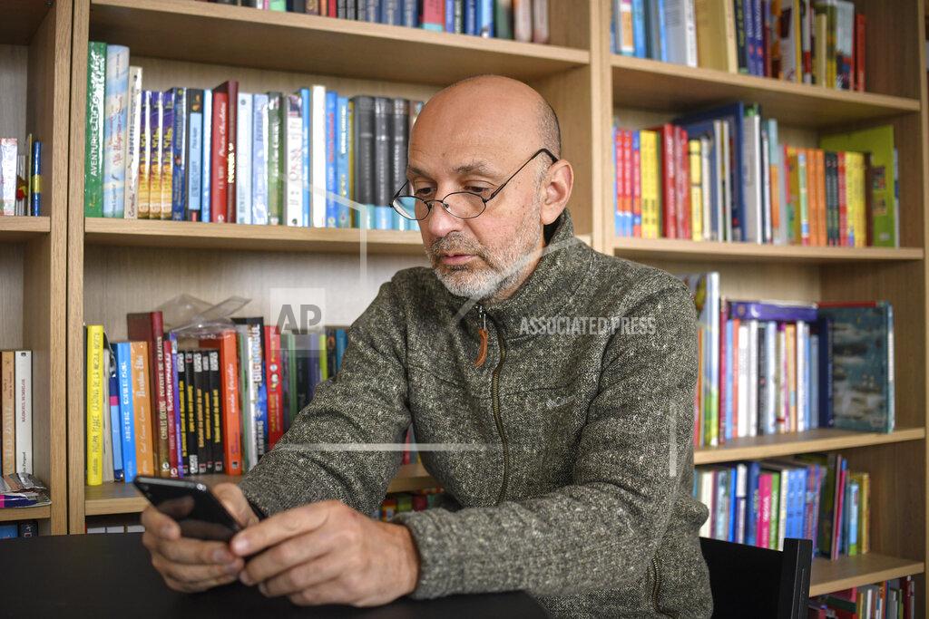 Andreea Alexandru Valeriu Nicolae, a Romanian Roma human rights activist, who runs as an independent in the upcoming parliamentary elections, looks at a mobile phone during an interview with the Associated Press, in Bucharest, Romania, Wednesday, Dec. 2, 2020. Romania will hold parliamentary elections on Sunday Dec. 6. (AP Photo/Andreea Alexandru)
