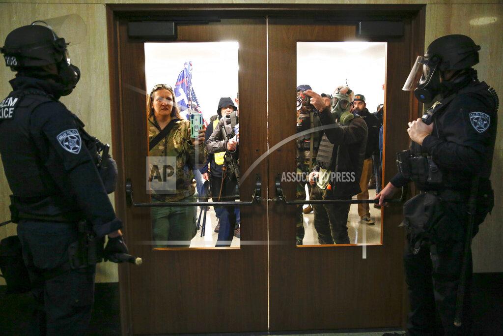Abigail Dollins FILE - In this Dec. 21, 2020, file photo, protesters try to get into the Oregon State Capitol during a special session of the state legislature in Salem, Ore. When President Trump-supporting insurrectionists stormed the U.S. Capitol in an attempt to overturn the presidential election on Wednesday, Jan. 6 2021 the nation was shocked, but not unwarned. A series of dress rehearsals of sorts have played out in statehouses in Michigan, Oregon, Idaho and elsewhere in recent months, with armed protesters forcing their way into buildings. (Abigail Dollins/Statesman-Journal via AP)