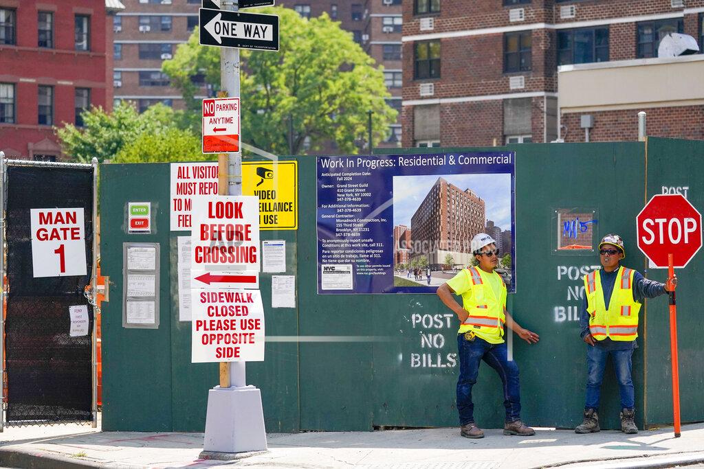 Mary Altaffer Construction workers help direct traffic outside a residential and commercial building under construction at the Essex Crossing development on the Lower East Side of Manhattan, Thursday, Aug. 4, 2022. On Friday, Aug. 5, the Labor Department delivers its July jobs report. (AP Photo/Mary Altaffer)