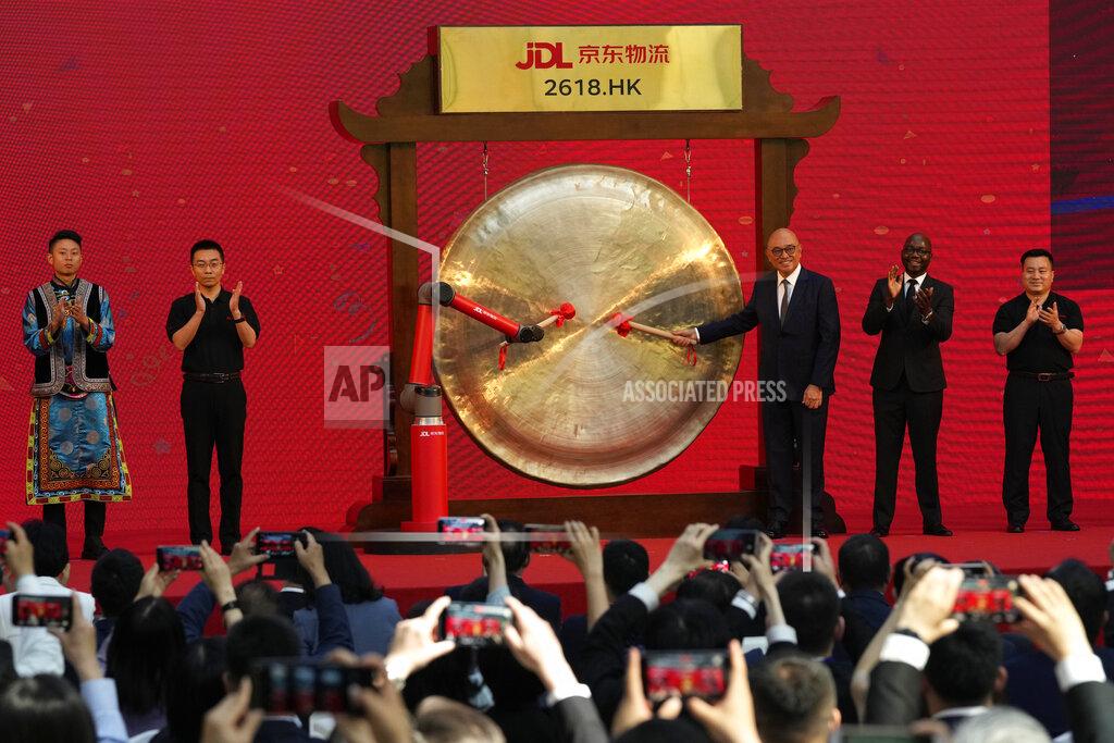 Willie Tan, an executive officer of Skechers Greater China, and customer of JD Logistics sound the gong together with a robot arm at a a ceremony to observe virtually the listing of JD Logistics on the Hong Kong stock exchange from JD.com headquarters in Beijing on Friday, May 28, 2021. JD Logistics' shares jumped 14% in their trading debut Friday in Hong Kong. The company is a subsidiary of Chinese e-commerce giant JD.com. It is the latest technology company to list in the semi-autonomous Chinese city as Beijing intensifies scrutiny of the technology sector. (AP Photo/Ng Han Guan)