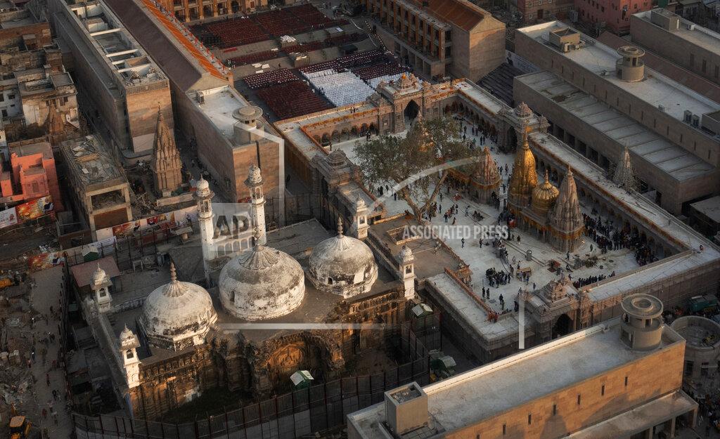 Rajesh Kumar Singh An Aerial view shows Gyanvapi mosque, left, and Kashiviswanath temple on the banks of the river Ganges in Varanasi, India, Dec. 12, 2021. A group of Hindus petitioned a local court seeking access to pray inside the mosque compound, saying they believe the Gyanvapi mosque in Varanasi, one of Hinduism’s holiest cities, was built on top of the ruins of a medieval-era temple and that the complex still houses Hindu idols and motifs, a claim that has been contested by the mosque authorities. (AP Photo/Rajesh Kumar Singh)
