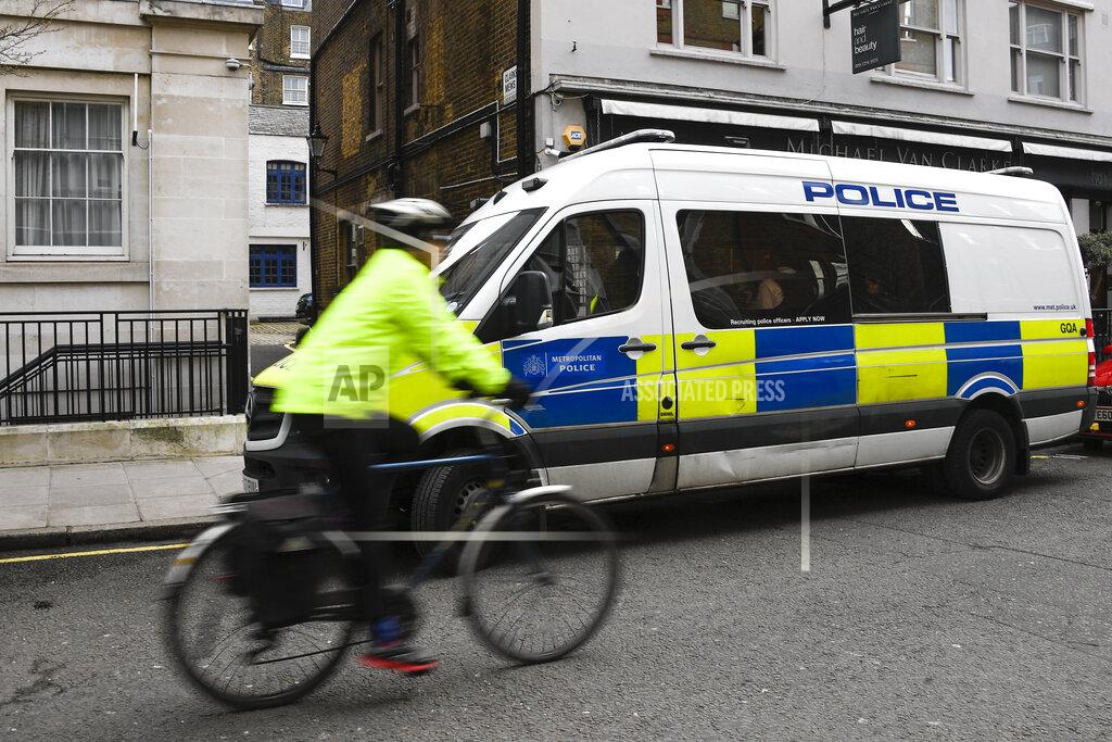 Alberto Pezzali A woman cycles past a Police van parked outside the King Edward VII hospital where Britain's Prince Philip is receiving treatment in London in London, Monday, March 15, 2021. The 99-year-old husband of Queen Elizabeth II remains hospitalized after a heart procedure. (AP Photo/Alberto Pezzali)