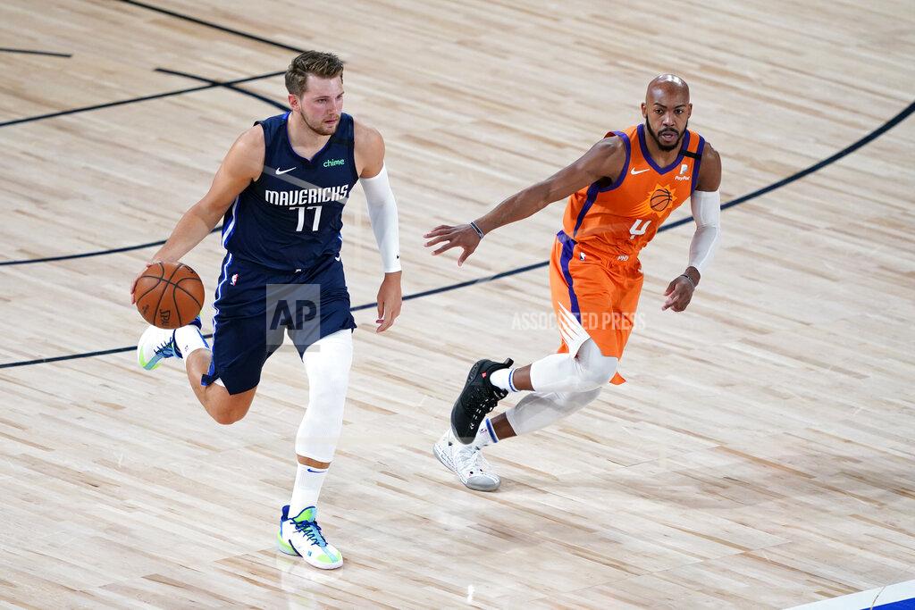 Ashley Landis Dallas Mavericks' Luka Doncic (77) brings the ball down the court as Phoenix Suns' Jevon Carter defends during the first half of an NBA basketball game Thursday, Aug. 13, 2020 in Lake Buena Vista, Fla. (AP Photo/Ashley Landis, Pool)