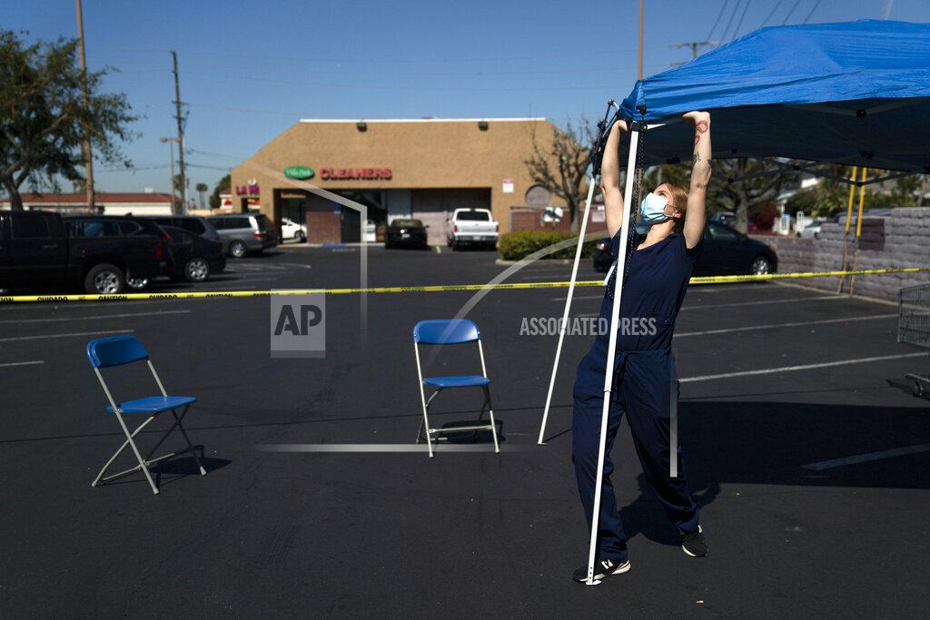 Jae C. Hong Medical assistant Abigail Osorio sets up a canopy in the observation area at a mobile COVID-19 vaccination clinic in the parking lot of a shopping center in Orange, Calif., Thursday, April 29, 2021. The mobile unit, launched in February by Families Together of Orange County, began its service to provide better access to the COVID-19 vaccine within the community and to prevent vaccine hesitation, according to mobile operations manager Parsia Jahanbani. (AP Photo/Jae C. Hong)