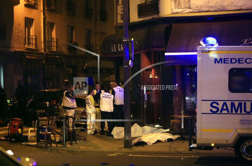 Thibault Camus FILE - In this Nov.13, 2015 file photo, medics stand by victims in a Paris restaurant, Friday, Nov. 13, 2015. On Nov. 13, 2015, a cell of nine Islamic State militants armed with automatic rifles and explosive vests left a trail of dead and injured at the national stadium, Paris bars and restaurants and the Bataclan concert hall. Nearly all the attackers were from France or Belgium, as were the cell's 10th member — the only one still alive. He is the chief defendant among 20 people charged in a trial that is expected to last nine months. (AP Photo/Thibault Camus, File)