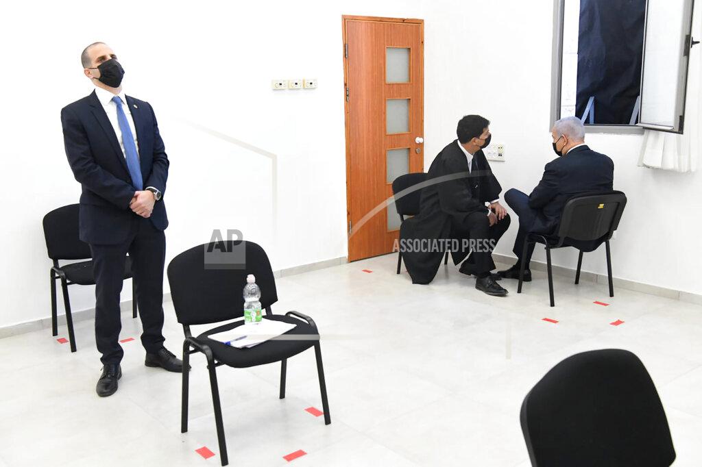 Israeli Prime Minister Benjamin Netanyahu, right, speaks with his lawyer prior to a hearing at the district court in Jerusalem, Monday, Feb. 8, 2021. Netanyahu appeared in a Jerusalem courtroom Monday to respond formally to corruption charges just weeks before national elections in which he hopes to extend his 12-year rule. (AP Photo/Reuven Castro, Pool)