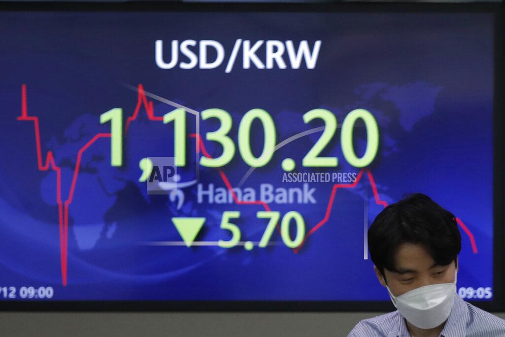 Lee Jin-Man A currency trader walks by the screen showing the foreign exchange rate between U.S. dollar and South Korean won at the foreign exchange dealing room in Seoul, South Korea, Friday, March 12, 2021. Stocks were mixed in Asia on Friday after broad gains lifted several major indexes to all-time highs on Wall Street.(AP Photo/Lee Jin-man)