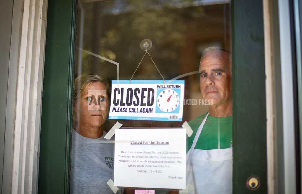 David Goldman Steve, right, and Chris Brophy, husband and wife owners of Brickley's Ice Cream, look out from the store they closed after teenage workers were harassed by customers who refused to wear a mask or socially distance, in Wakefield, R.I., Wednesday, July 29, 2020. "Some of them don't believe it's real (COVID-19) and some don't think it's a big deal, I do," Steve Brophy said, adding that he would rather close than put young workers and customers at risk of harassment, and the virus. "It's like it's OK to be a jerk in this environment." (AP Photo/David Goldman)