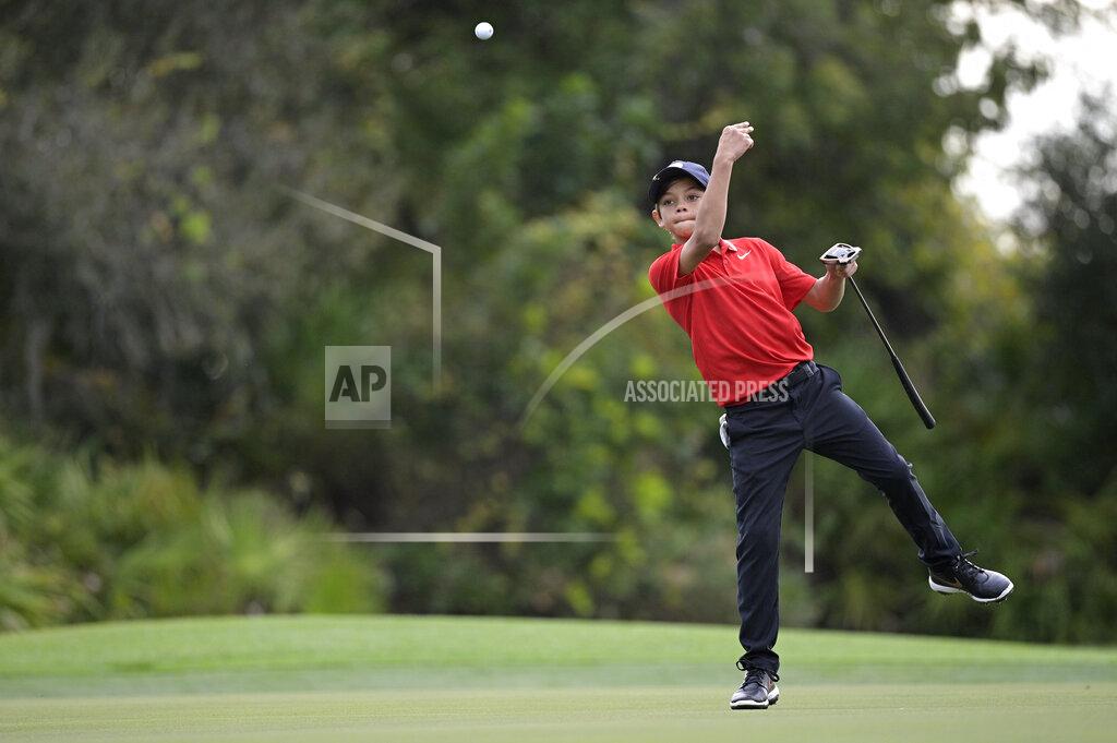 Phelan M. Ebenhack Charlie Woods, son of golfer Tiger Woods, tosses a ball to his caddie after marking his spot on the third green during the final round of the PNC Championship golf tournament, Sunday, Dec. 20, 2020, in Orlando, Fla. (AP Photo/Phelan M. Ebenhack)
