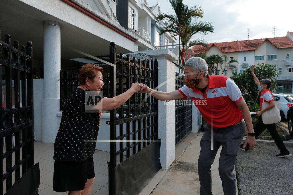 Ee Ming Toh Lee Hsien Yang, the estranged brother of Singapore Prime Minister Lee Hsien Loong, wears a face mask while doing a fist bump with a female resident at a private estate in Jurong West during a walkabout campaign for the opposition Progress Singapore Party in Singapore on July 8, 2020. Singaporeans go to the polls on July 10 in Southeast Asia's first election since the coronavirus pandemic began, with the health crisis and an economic recession expected to bolster Prime Minister Lee's party and extend its unbroken rule. (AP Photo/Ee Ming Toh)