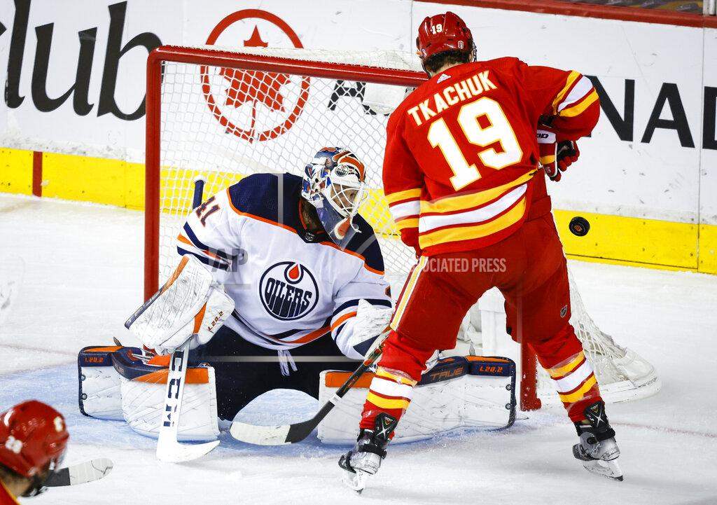 Jeff Mcintosh Edmonton Oilers goalie Mike Smith, left, deflects a shot wide of the net as Calgary Flames' Matthew Tkachuk looks for a rebound during the second period of Game 5 of an NHL hockey second-round playoff series Thursday, May 26, 2022, in Calgary, Alberta. (Jeff McIntosh/The Canadian Press via AP)