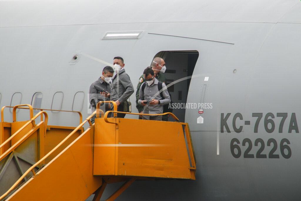 Justin Kabumba Unidentified people stand on the boarding stairs of an airplane after it arrived to transport the bodies of Italian ambassador to Congo Luca Attanasio and Carabinieri officer Vittorio Iacovacci to the capital Kinshasa, at the airport in Goma, North Kivu province, Congo Tuesday, Feb. 23, 2021. Congo has dispatched a team to support investigators on the ground in Goma where the Italian ambassador to Congo, an Italian Carabinieri police officer and their driver were ambushed and killed Monday. (AP Photo/Justin Kabumba)