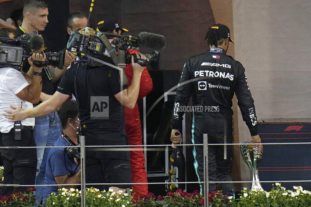 Hassan Ammar Mercedes driver Lewis Hamilton of Britain leaves the podium after finishing second in the Formula One Abu Dhabi Grand Prix in Abu Dhabi, United Arab Emirates, Sunday, Dec. 12, 2021. Max Verstappen ripped a record eighth title away from Lewis Hamilton with a pass on the final lap of the Abu Dhabi GP to close one of the most thrilling Formula One seasons in years as the first Dutch world champion. (AP Photo/Hassan Ammar)