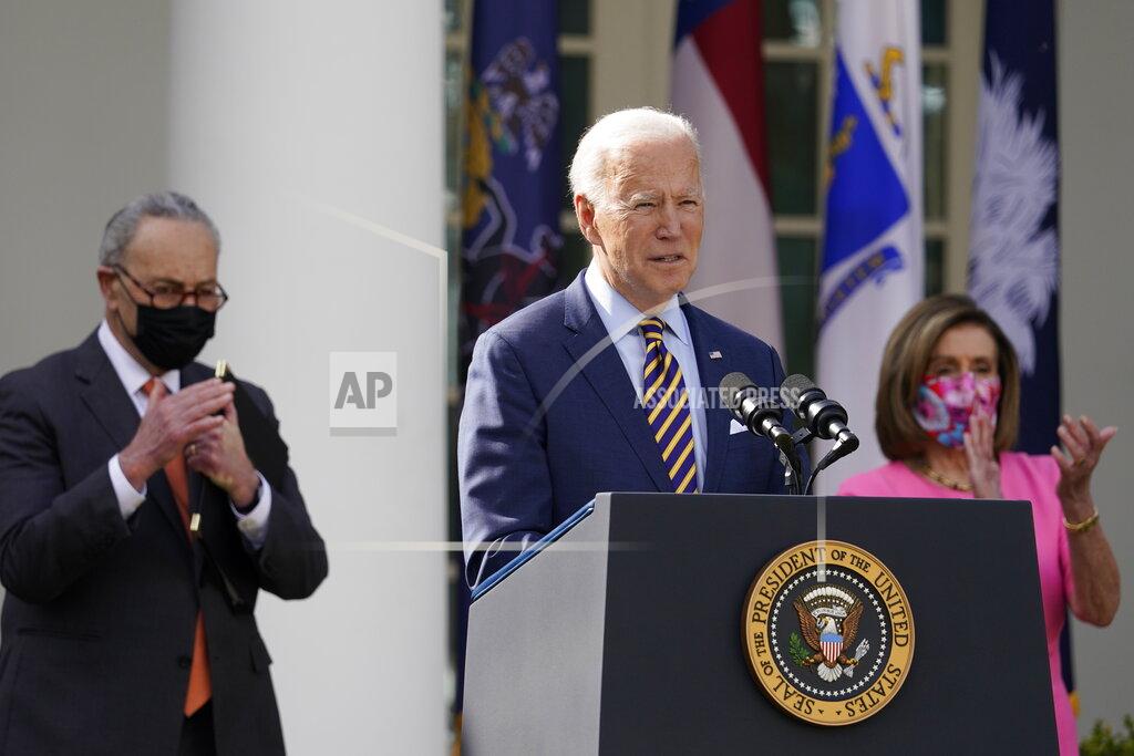 Alex Brandon FILE - In this March 12, 2021, file photo President Joe Biden speaks about the American Rescue Plan, a coronavirus relief package, in the Rose Garden of the White House in Washington. Senate Majority Leader Chuck Schumer of N.Y., left, and House Speaker Nancy Pelosi of Calif., listen. (AP Photo/Alex Brandon, File)