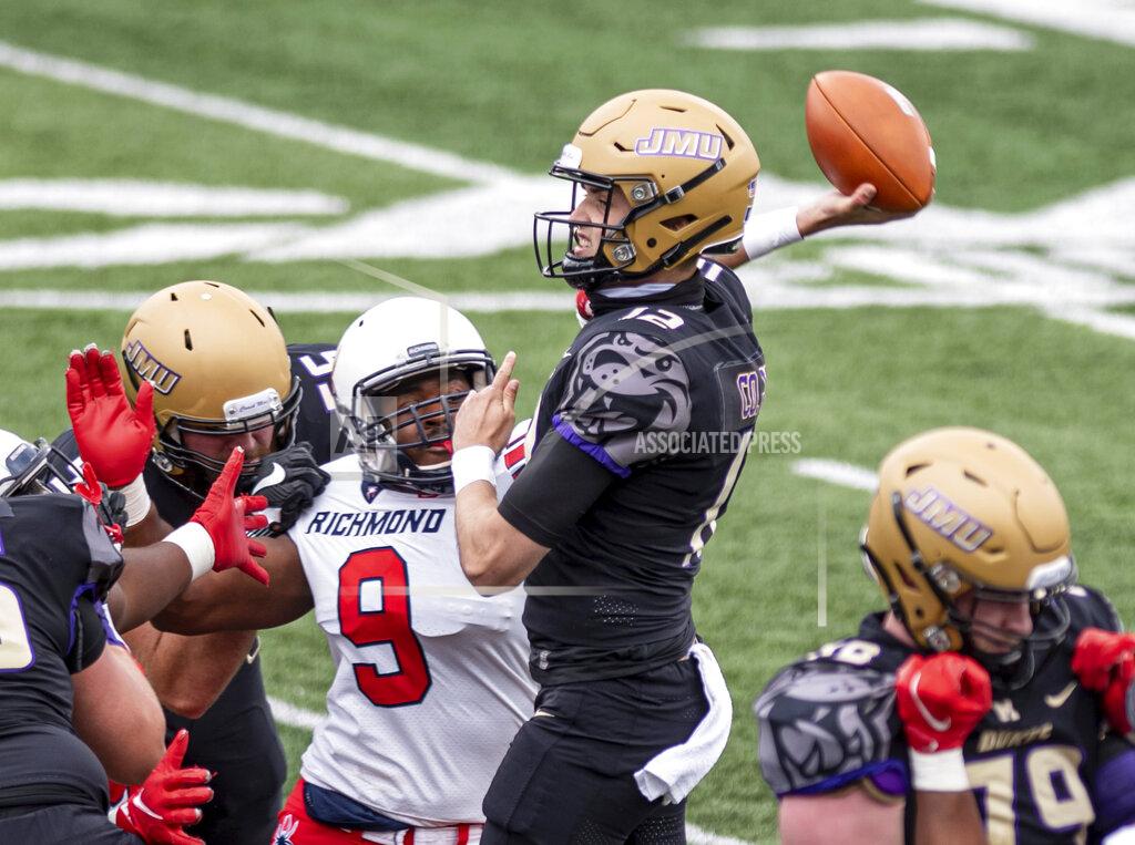 Daniel Lin James Madison quarterback Cole Johnson (12) winds up a pass as Richmond defensive lineman Darius Reynolds (9) closes in for the tackle during the first half of an NCAA college football game in Harrisonburg, Va., Saturday, April 17, 2021. (Daniel Lin/Daily News-Record Via AP)