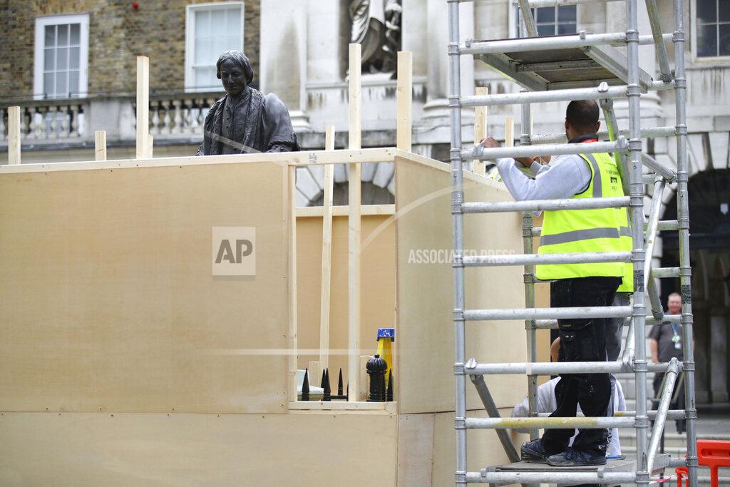 Aaron Chown A protective hoarding is erected around a statue of Thomas Guy, outside Guy's hospital in London, following a raft of Black Lives Matter protests across the UK. Protests sparked by the death of George Floyd, who was killed while in police custody in the US city of Minneapolis, has sparked a wider debate about the UK's colonial past. Guy's and St Thomas' NHS Foundation Trust confirmed two figures depicting Robert Clayton and Thomas Guy will be taken out of public view due to their association with the slave trade. (Aaron Chown/PA via AP)