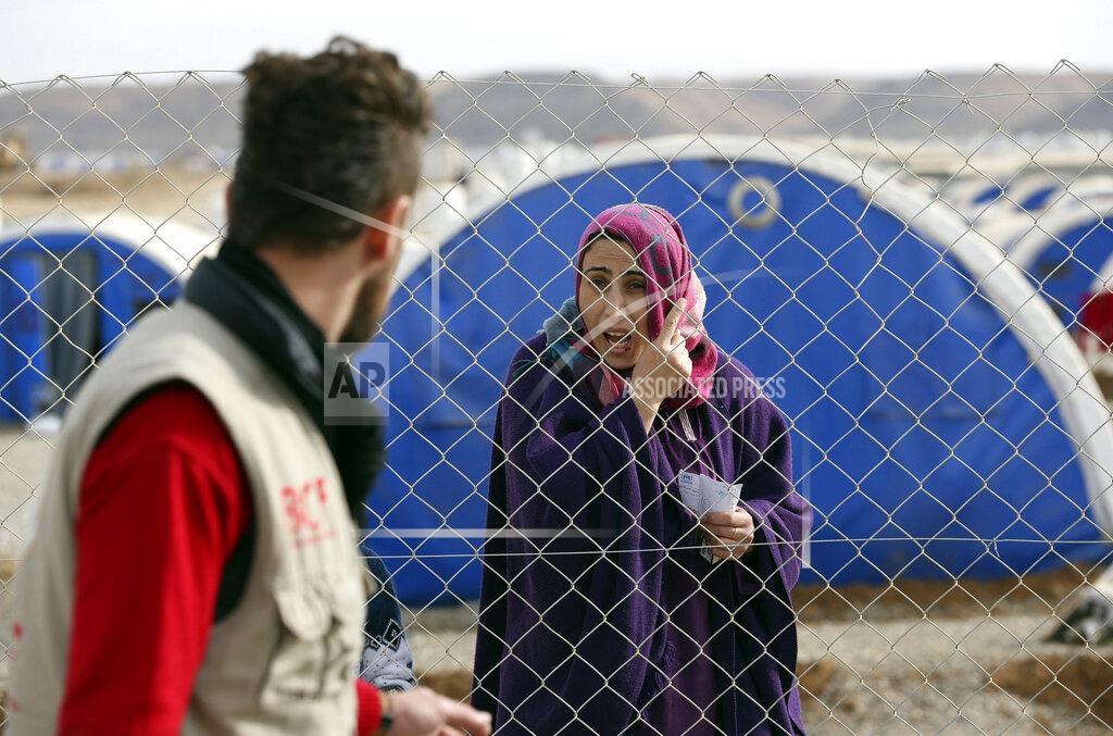 FILE - In this Dec. 5, 2016 file photo, an Iraqi woman who fled the fighting between Iraqi security forces and Islamic State militants waits for humanitarian aid at a camp for internally displaced people, in Khazir, near Mosul, Iraq. A new report released Monday, May 11, 2020, by the Norwegian Refugee Council found that internally displaced women will face more obstacles returning home than men after nearly three years of languishing in camps since the end of the war against the Islamic State. At least 11 % of women, the report says, will face barriers hindering their return including tribal conflicts and militia presence. (AP Photo/Hadi Mizban, File)