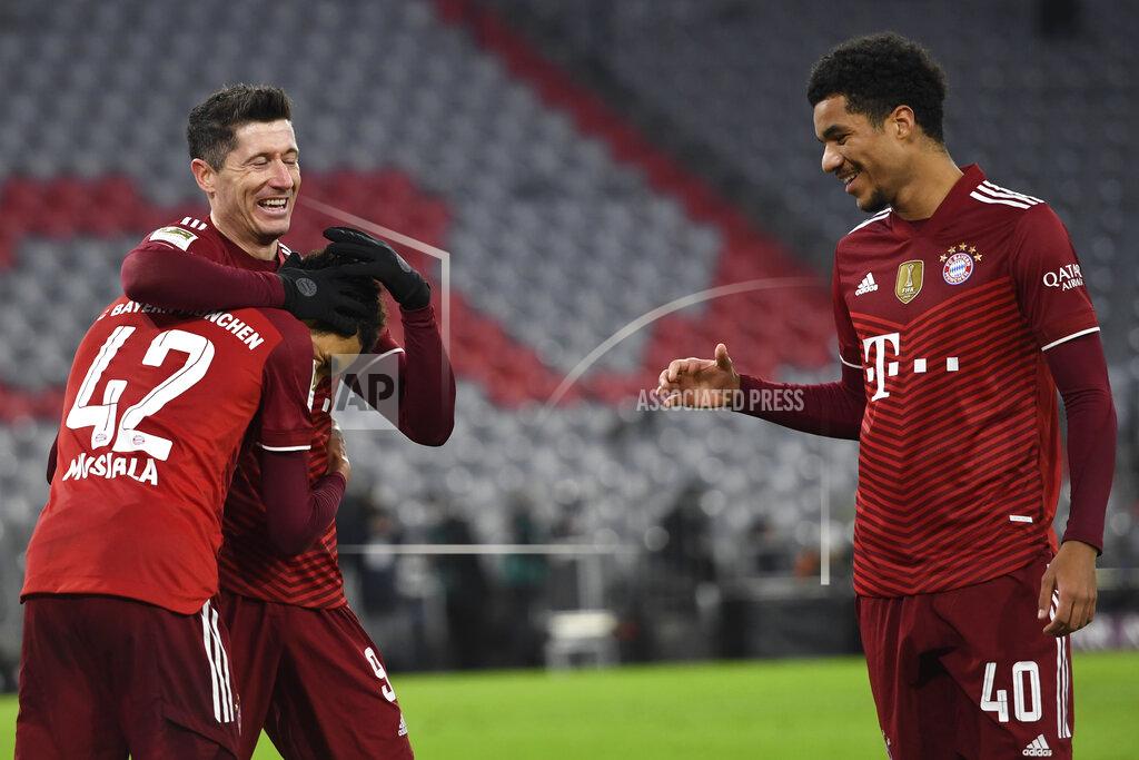 Andreas Schaad FILE - Bayern Munich's Robert Lewandowski, center, celebrates with teammates Jamal Musiala, left, and Malik Tillman, right, after scoring his side's fourth goal during a German Bundesliga soccer match against VfL Wolfsburg at the Allianz Arena in Munich, Germany, Dec. 17, 2021. Bayern Munich midfielder Tillman is switching affiliation from Germany to the United States and is among 27 players invited to the Americans’ next-to-last training camp ahead of the World Cup. (AP Photo/Andreas Schaad, File)