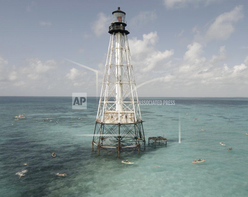 Steve Panariello In this photo provided by the Florida Keys News Bureau, competitors in the Swim for Alligator Lighthouse, an open-water, long-distance event, round the Florida Keys lighthouse and head to shore Saturday, Sept. 11, 2021, near Islamorada, Fla. The event began in 2013 to help raise awareness about preserving the almost 150-year-old lighthouse as well as five other lighthouses off the Keys. This year's contest attracted 461 swimmers. (Steve Panariello/Florida Keys News Bureau via AP)