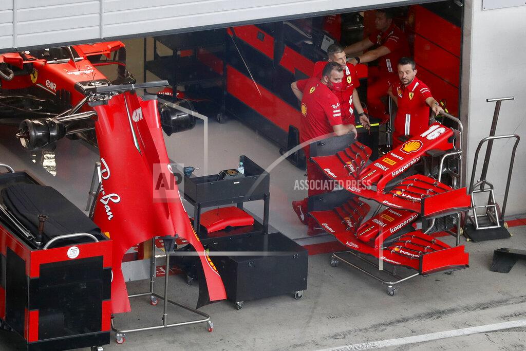 Ferrari technicians pause as they work on Sebastian Vettel's car the at the Red Bull Ring racetrack in Spielberg in Spielberg, Austria, Thursday, July 2, 2020. Austrian Formula One Grand Prix will be held on Sunday. (AP Photo/Darko Bandic)