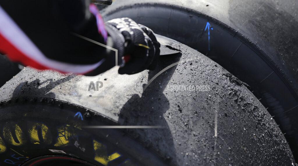 Charles Krupa A crew member scrapes the molten rubber surface off a tire following a pit stop during a NASCAR Cup Series auto race at New Hampshire Motor Speedway in Loudon, N.H., Sunday, July 21, 2019. (AP Photo/Charles Krupa)