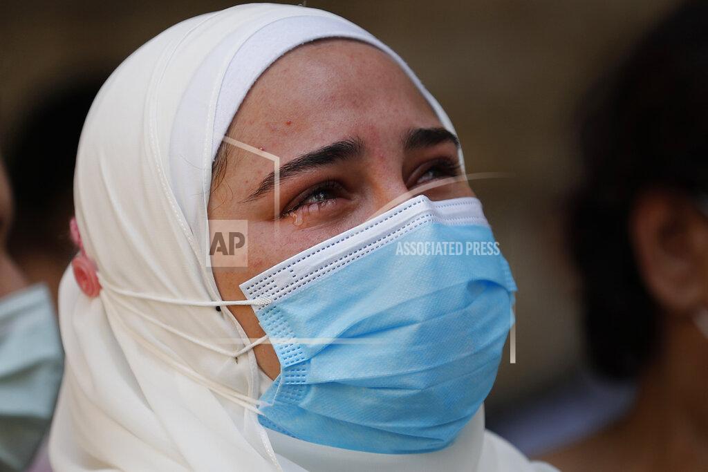 Hussein Malla The fiancé of Ibrahim Harb, 35, a Lebanese man who was critically injured in the massive explosion at Beirut's port last year and who died on Monday nearly 14 months after the blast, mourns during his funeral procession in Beirut, Lebanon, Tuesday, Sept. 28, 2021. On Aug. 4, 2020, hundreds of tons of ammonium nitrate, a highly explosive material used in fertilizers, ignited after a massive fire at the port. The death brings to at least 215 the number of people who have been killed by the blast, according to official records. (AP Photo/Hussein Malla)