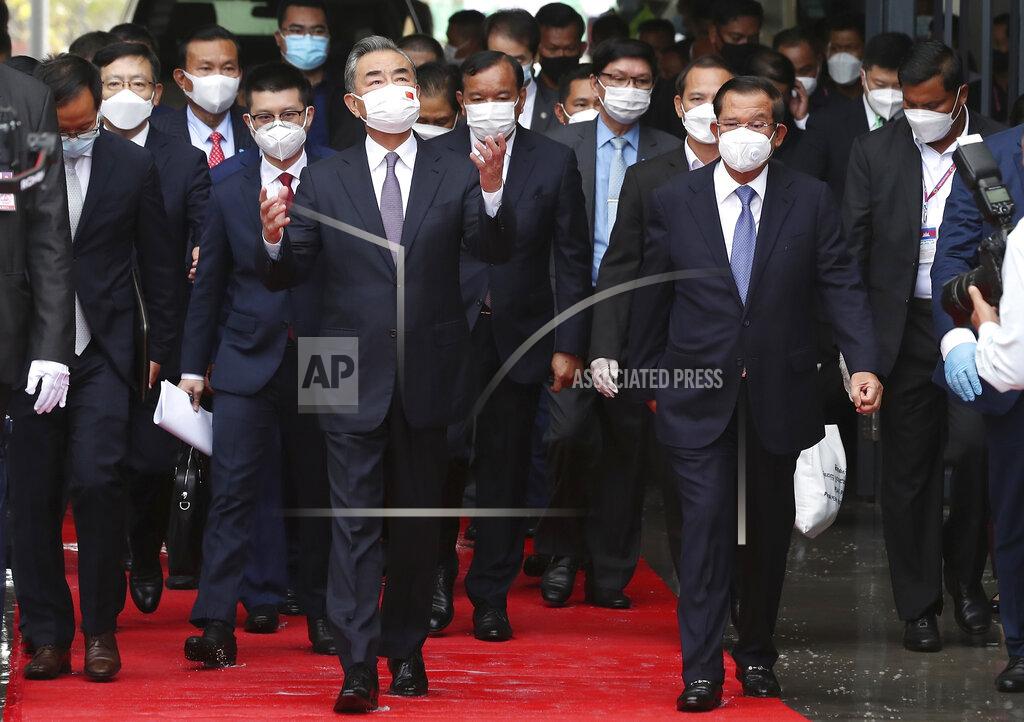 Lon Jadina Chinese Foreign Minister Wang Yi, front left, walks with Cambodia's Prime Minister Hun Sen, front right, during a tour to the Morodok Techo National Stadium, as it was handed over to the the Cambodian organizing committee of the Southeast Asian Games, in Phnom Penh, Cambodia, Sunday, Sept. 12, 2021. Wang is visiting Cambodia, where he met with Hun Sen and other officials to discuss COVID-19 and other regional issues. (Lon Jadina/Pool Photo via AP)