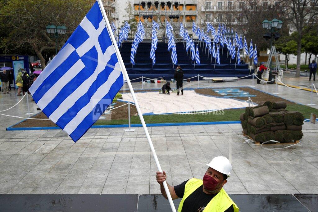 Thanassis Stavrakis A worker places a Greek flag at a tribune, ahead of a military parade, in Athens, Tuesday, March 23, 2021. The military parade on March 25, marking 200-years since the war that resulted in Greece's independence from the Ottoman Empire and rebirth as a nation, will be held without spectators due to the coronavirus. (AP Photo/Thanassis Stavrakis)