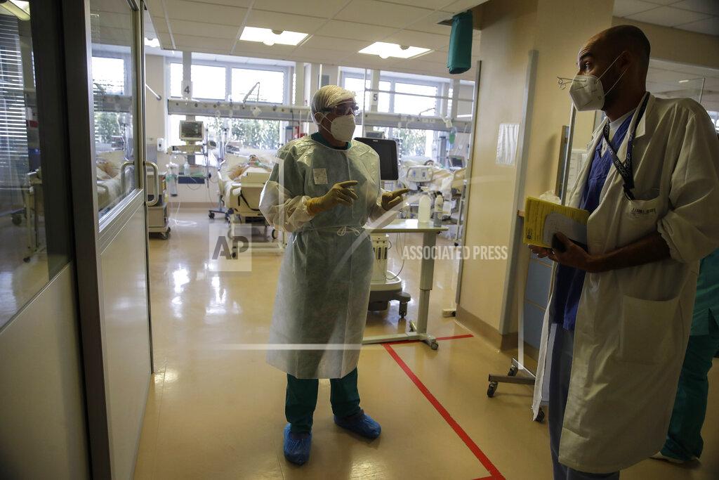 Luca Bruno Doctor Davide Maraggia, left, talks to anestesyologist Luca Guzzetti, in the Intensive Care Unit of the Varese’s Circolo Hospital, in Varese, Italy, Friday, Nov. 6, 2020. During Italy's autumn pandemic resurgence, concern is falling less on intensive care wards and more on regular medical wards, as eight regions have seen the needle move alarmingly into the red-alert zone with more than half of hospital beds dedicated to coronavirus patients. (AP Photo/Luca Bruno)