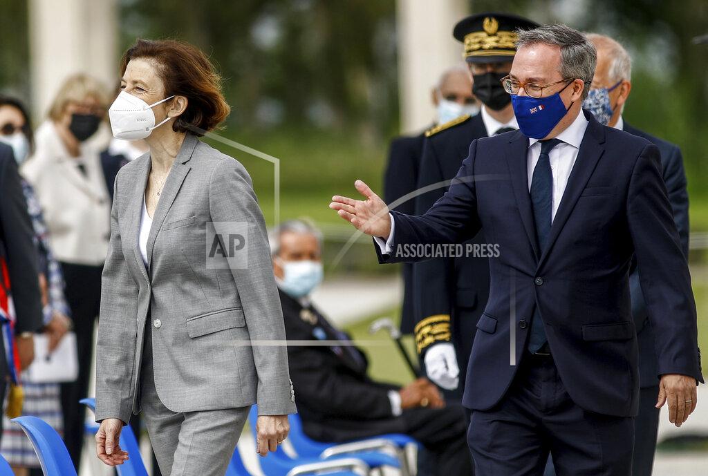 Sameer Al-Doumy British ambassador to France, Edward Llewellyn, right, arrives with French Defense Minister Florence Parly for the inauguration of the British Normandy Memorial, in Ver-sur-Mer, France, Sunday, June 6, 2021. The monument, built under a project launched in 2016, pays tribute to those under British command who died on D-Day and during the Battle of Normandy. The names of more than 22,000 men and women, mostly British soldiers, are written on its stone columns. (Sameer Al-Doumy/Pool via AP)