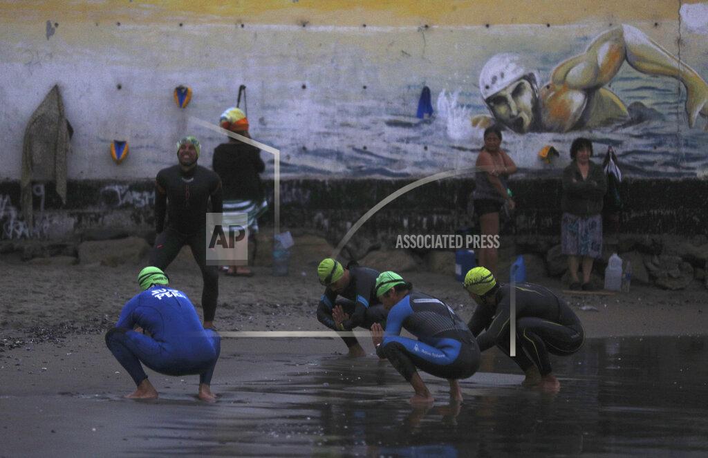 Martin Mejia Open sea swimmers warm-up on Pescadores beach in Lima, Peru, at sunrise Tuesday, April 27, 2021. One of the few sporting disciplines that have been maintained during the coronavirus pandemic is swimming, which due to the closure of the swimming pools, has moved to the open sea. (AP Photo/Martin Mejia)