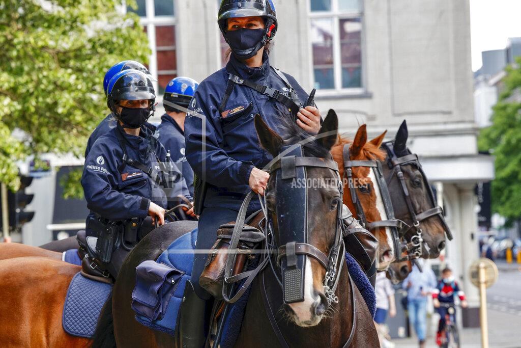 Olivier Matthys Mounted police officers patrol as people gather near EU headquarters during a so called "European Demonstration for Freedom and Democracy" protest against COVID-19 security measures taken by European governments, in Brussels, Saturday, May 29, 2021. (AP Photo/Olivier Matthys)