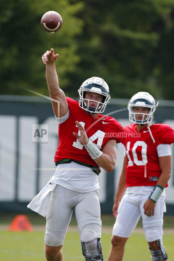Al Goldis Michigan State quarterback Brian Lewerke, left, throws a pass during an NCAA college football practice, Monday, Aug. 12, 2019, in East Lansing, Mich. (AP Photo/Al Goldis)