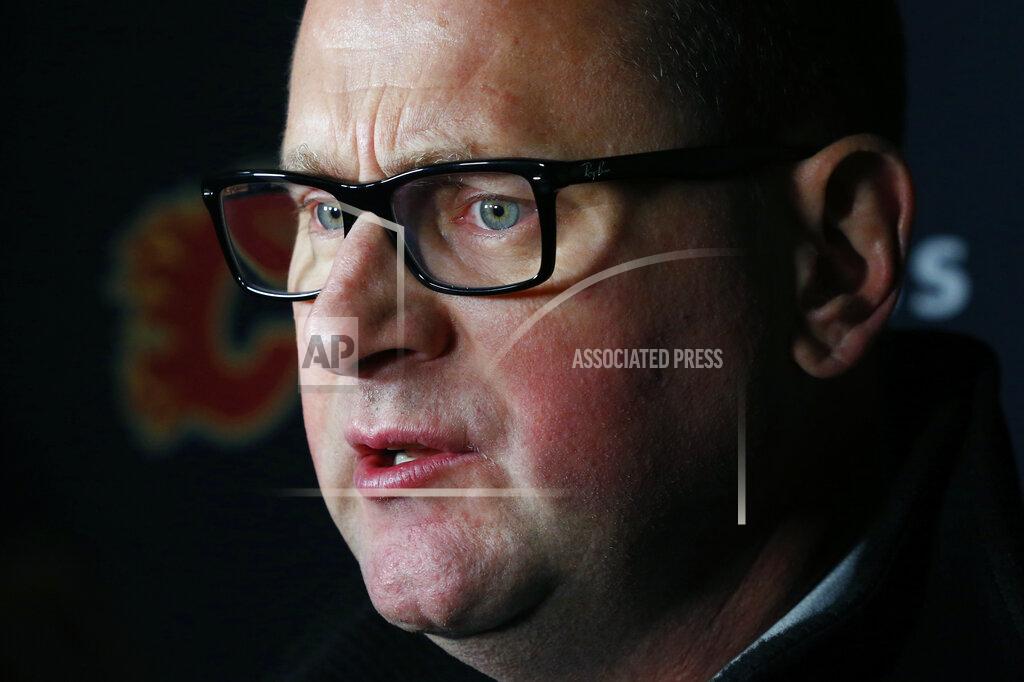 Jeffrey T. Barnes Calgary Flames General Manager Brad Treliving addresses the media following an NHL hockey practice Tuesday, Nov. 26, 2019, in Buffalo, N.Y. Treliving says Flames coach Bill Peters remains on the staff but wasn’t certain whether he’d be behind the bench for the next game. The team and the NHL are both investigating an allegation the Peters directed racial slurs at a player 10 years ago when the two were in the minors. Akim Aliu, a Nigerian-born player, says Peters “dropped the N bomb several times” in a dressing room during his rookie year.(AP Photo/Jeffrey T. Barnes)