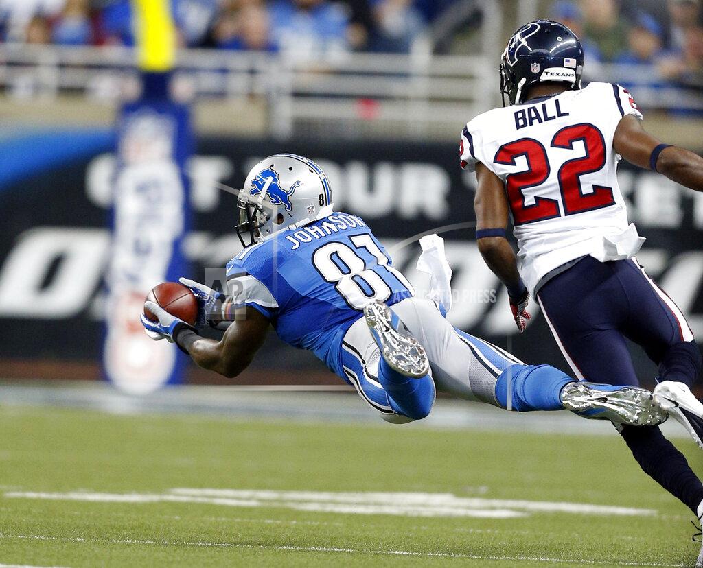 Rick Osentoski FILE - In this Nov. 22, 2012, file photo, Detroit Lions wide receiver Calvin Johnson (81) makes a diving catch as Houston Texans defensive back Alan Ball (22) defends during the first quarter of an NFL football game in Detroit. With the NFL increasing its season to 17 games for the first change in length of the season since going from 14 to 16 games in 1978, some records and milestones could soon be threatened by even more players. In an era where records have been falling with frequency, one mark that hasn’t been reached is 2,000 yards receiving in a season. Johnson came closest with 1,964 yards in 2012. (AP Photo/Rick Osentoski, File)