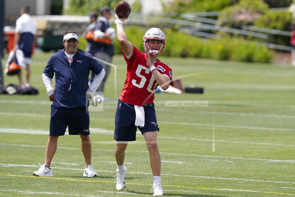 Steven Senne New England Patriots quarterback Mac Jones (50) passes the ball as offensive coordinator Josh McDaniels, left, looks on during an NFL football practice in Foxborough, Mass., Thursday, June 10, 2021. (AP Photo/Steven Senne)
