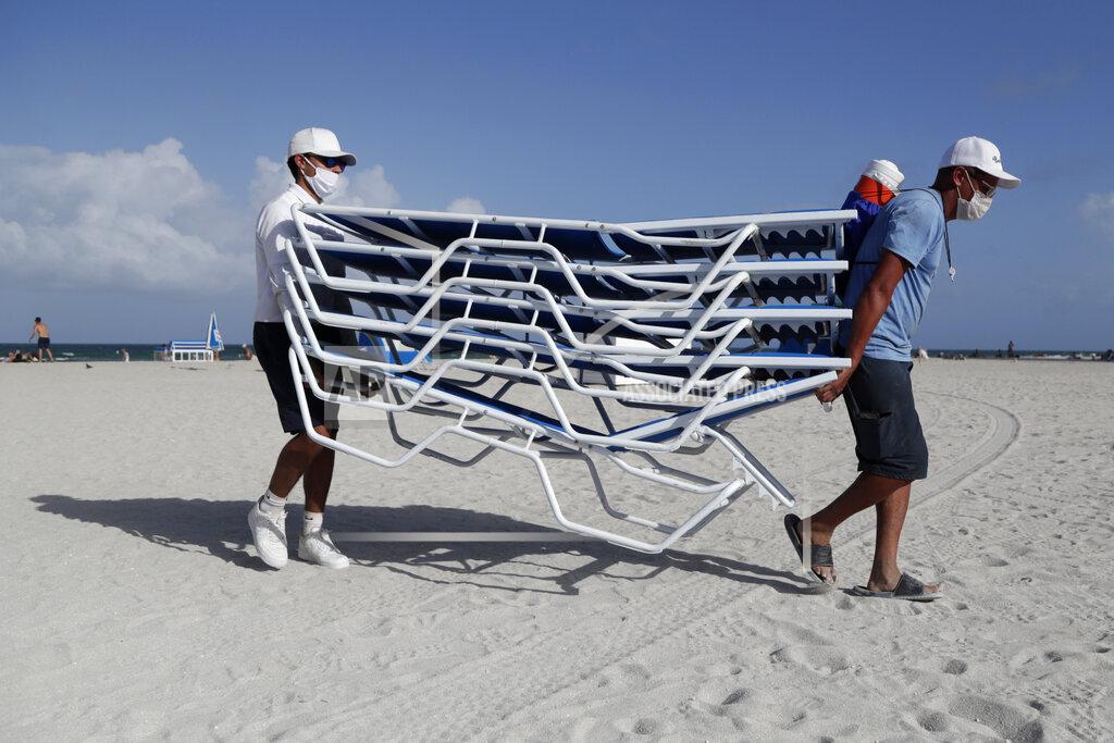 Lynne Sladky Workers remove chairs from the beach in preparation for Hurricane Isaias, Friday, July 31, 2020, in Miami Beach, Fla. Forecasters declared a hurricane warning for parts of the Florida coast Friday as Hurricane Isaias drenched the Bahamas on track for the U.S. East Coast. (AP Photo/Lynne Sladky)