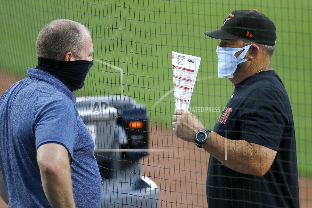Julio Cortez Baltimore Orioles director of baseball administration Kevin Buck, left, and field coordinator Tim Cossins wear masks to protect against COVID-19 as they talk during an intrasquad game at baseball training camp Tuesday, July 14, 2020, in Baltimore. (AP Photo/Julio Cortez)