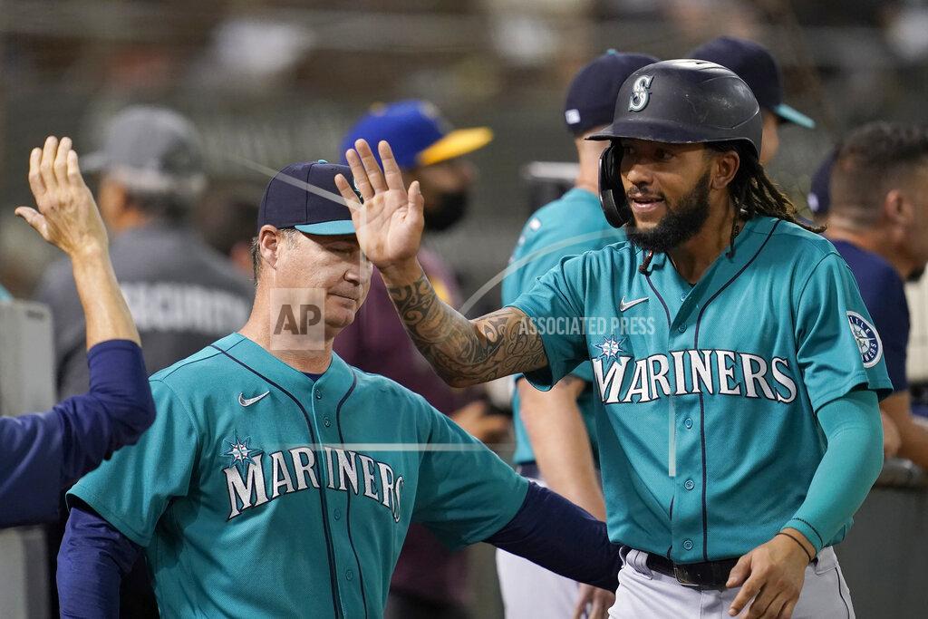 Jeff Chiu Seattle Mariners' J.P. Crawford, right, is congratulated by manager Scott Servais, left, and teammates after scoring a run against the Oakland Athletics during the third inning of a baseball game in Oakland, Calif., Monday, Sept. 20, 2021. (AP Photo/Jeff Chiu)