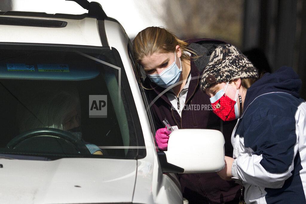 C.b. Schmelter University of Tennessee at Chattanooga nursing student Lauren Buffington, center, and Hamilton County Health Department worker Shelly Donahue, right, help distribute the COVID-19 vaccine near the Hubert Fry Center at the Tennessee Riverpark on Wednesday, Dec. 30, 2020, in Chattanooga, Tenn. The Hamilton County Health Department continued distributing vaccines following the State of Tennessee's response plan at their Vaccination Drive-Thru Point of Dispensing. (C.B. Schmelter/Chattanooga Times Free Press via AP)