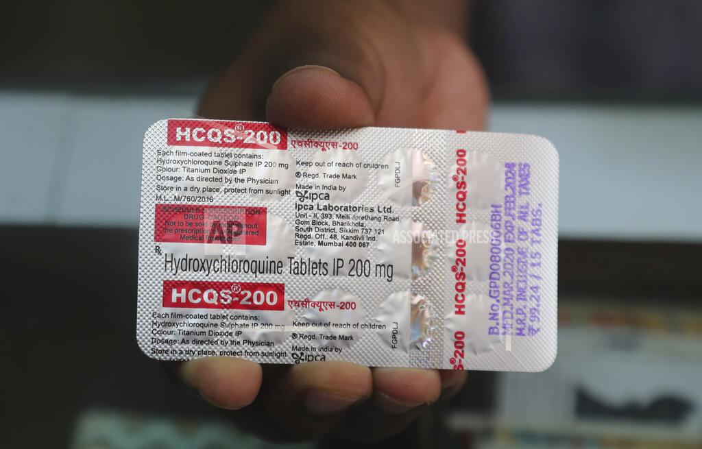 FILE- In this May 19, 2020 file photo, a chemist displays hydroxychloroquine tablets in Mumbai, India. With India’s surge exploding, people are resorting to medical treatments that have not been approved internationally for COVID-19, causing shortages and booming black markets. Drugs such as hydroxychloroquine, which the WHO has strongly recommended not be used for coronavirus, are being used by desperate patients. (AP Photo/Rafiq Maqbool, File)