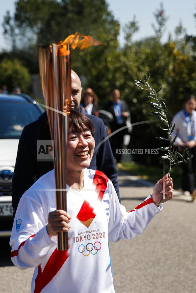 Thanassis Stavrakis Japanese Olympic marathon champion, Mizuki Noguch, the second torchbearer, holds the torch following the flame lighting ceremony at the closed Ancient Olympia site, birthplace of the ancient Olympics in southern Greece, Thursday, March 12, 2020, 2020. Greek Olympic officials are holding a pared-down flame-lighting ceremony for the Tokyo Games due to concerns over the spread of the coronavirus. Both Wednesday's dress rehearsal and Thursday's lighting ceremony are closed to the public, while organizers have slashed the number of officials from the International Olympic Committee and the Tokyo Organizing Committee, as well as journalists at the flame-lighting. (AP Photo/Thanassis Stavrakis)